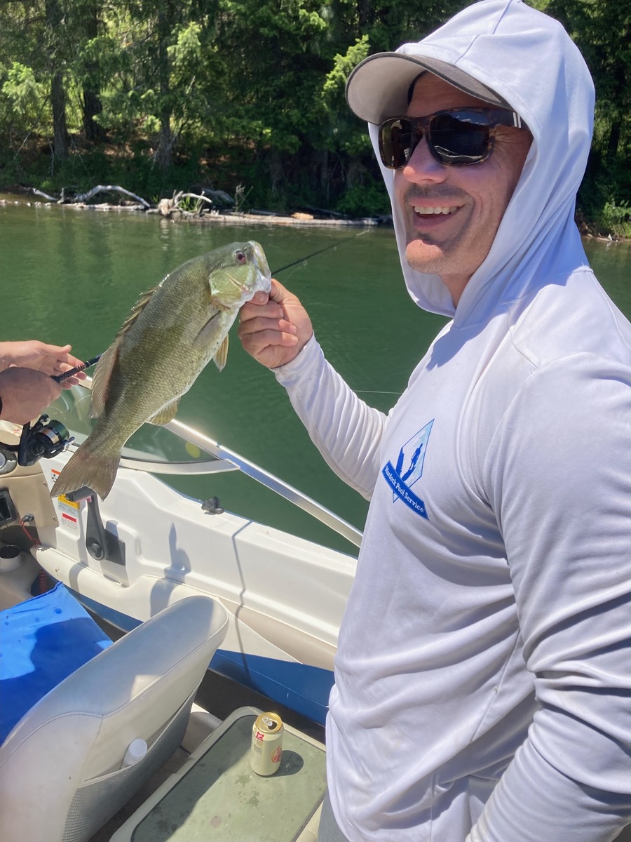 Brett Murdock, owner of Murdock Pool Service, holding a fish caught on a fishing trip